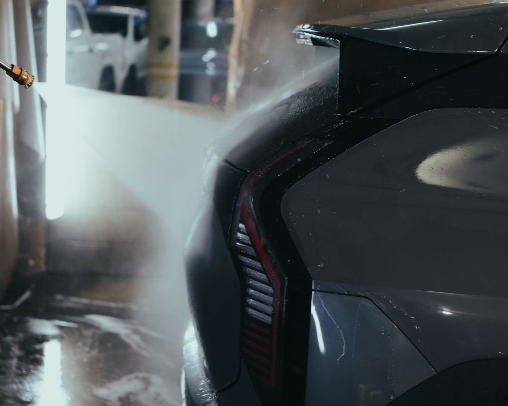 Steam rising off an EV tail light during a hot decontamination wash