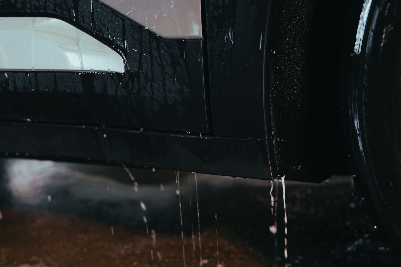 Water sheeting off the protected lower panels of an EV in the Brisbane studio