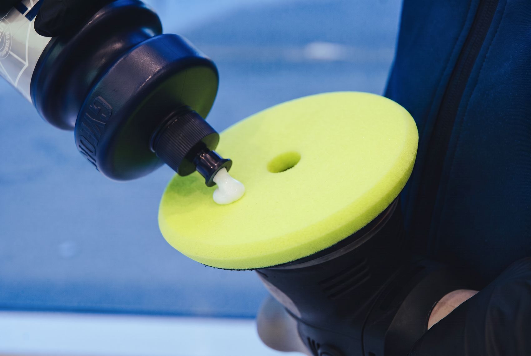 Ceramic coating being dispensed onto a machine-polishing pad at EV Auto Specialist